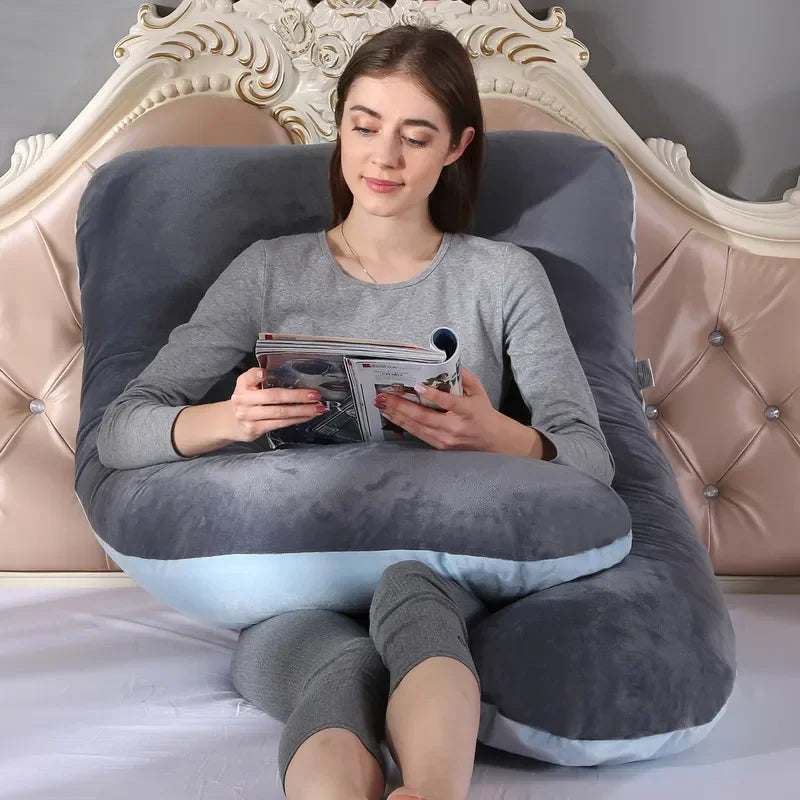 Woman using the dark grey pillow to support her back while reading a magazine in the bedroom.