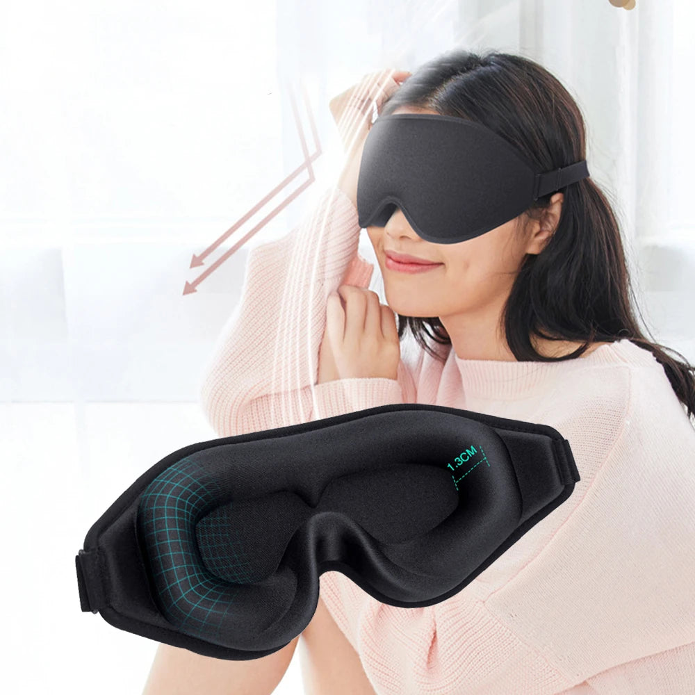 Woman wearing a black sleep mask which is able to block 100% of light.