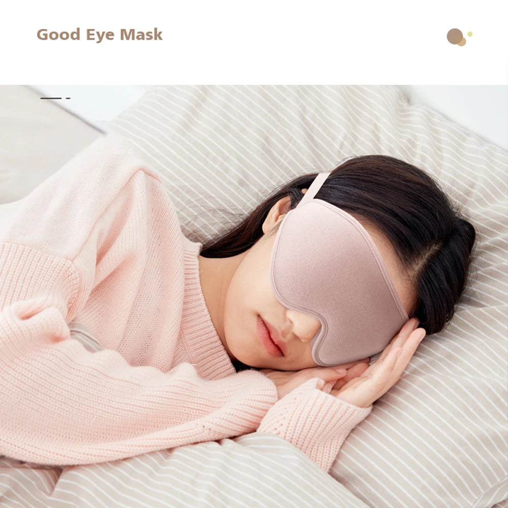 Woman wearing a comfortable pink eye mask while sleeping on a bed.
