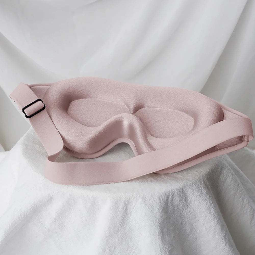Pink sleep mask on a white fabric background