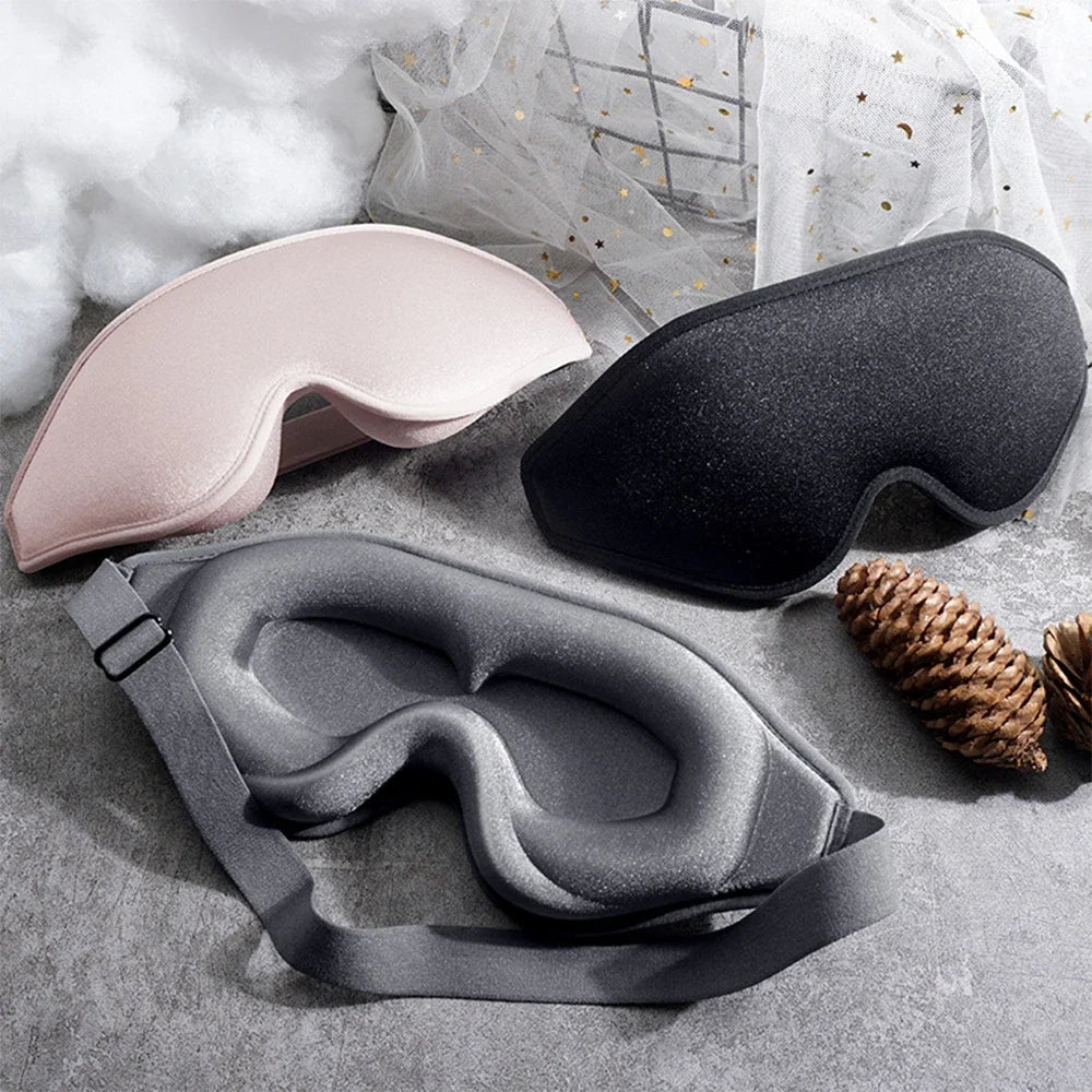 Three sleep masks in grey, pink, and black.