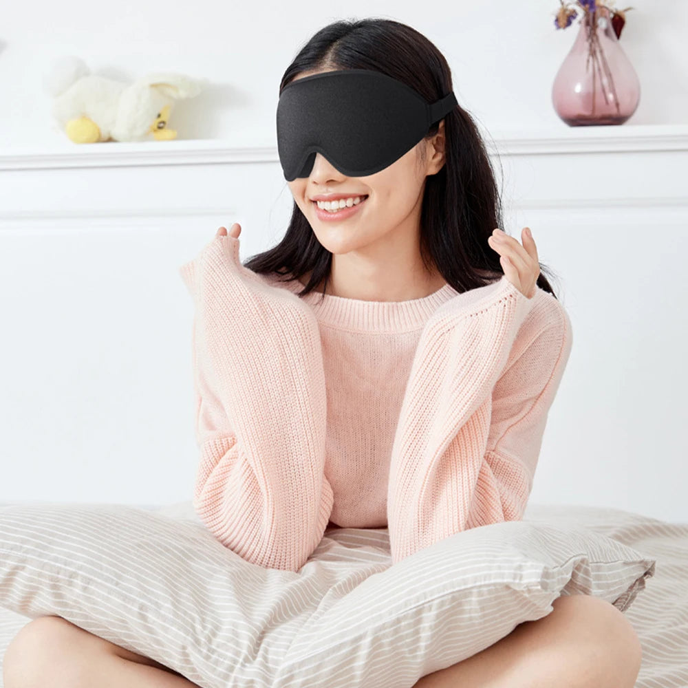 Woman wearing a black sleep mask and feeling comfortable in a cosy room.
