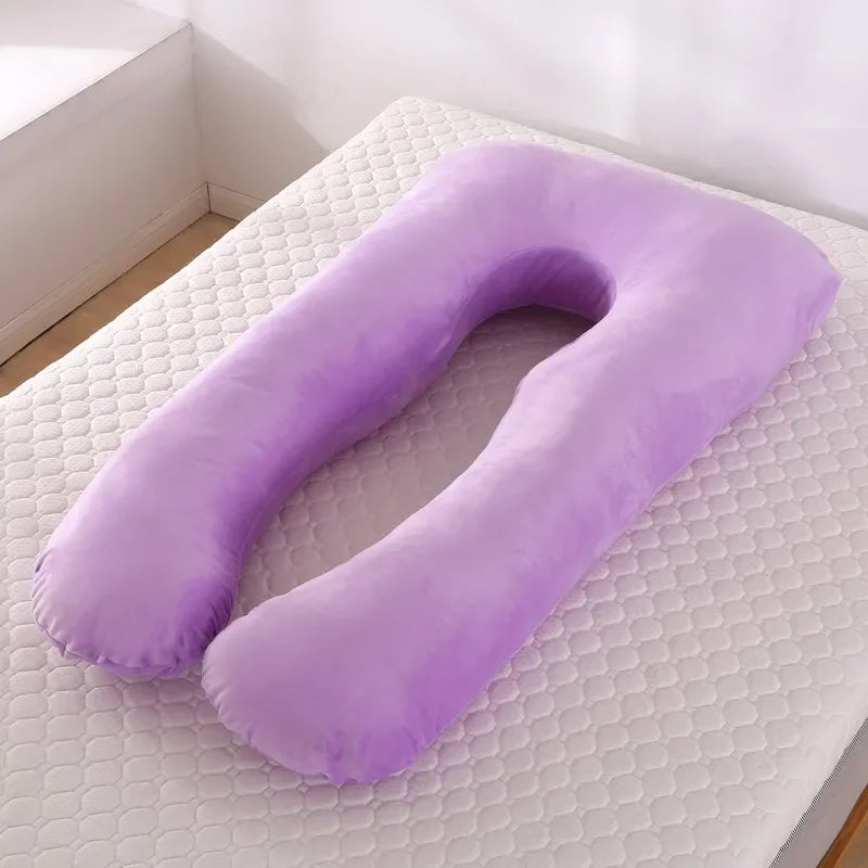 Purple U-shaped body pillow on a mattress