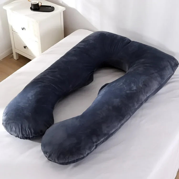 Dark grey U-shaped body pillow in a bedroom.