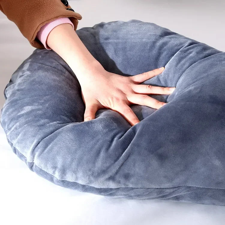Soft dark blue donut-shaped pillow soft enough for a hand to rest on it.