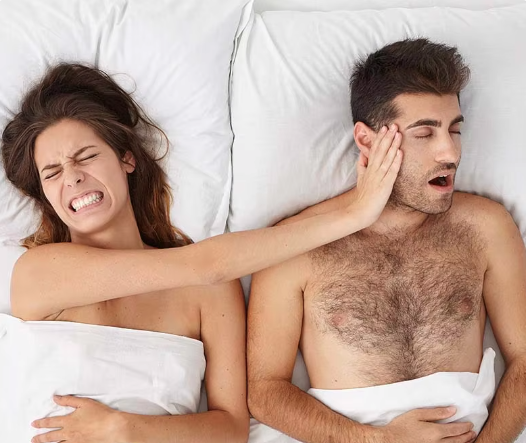 Man snoring and woman blocking her ears