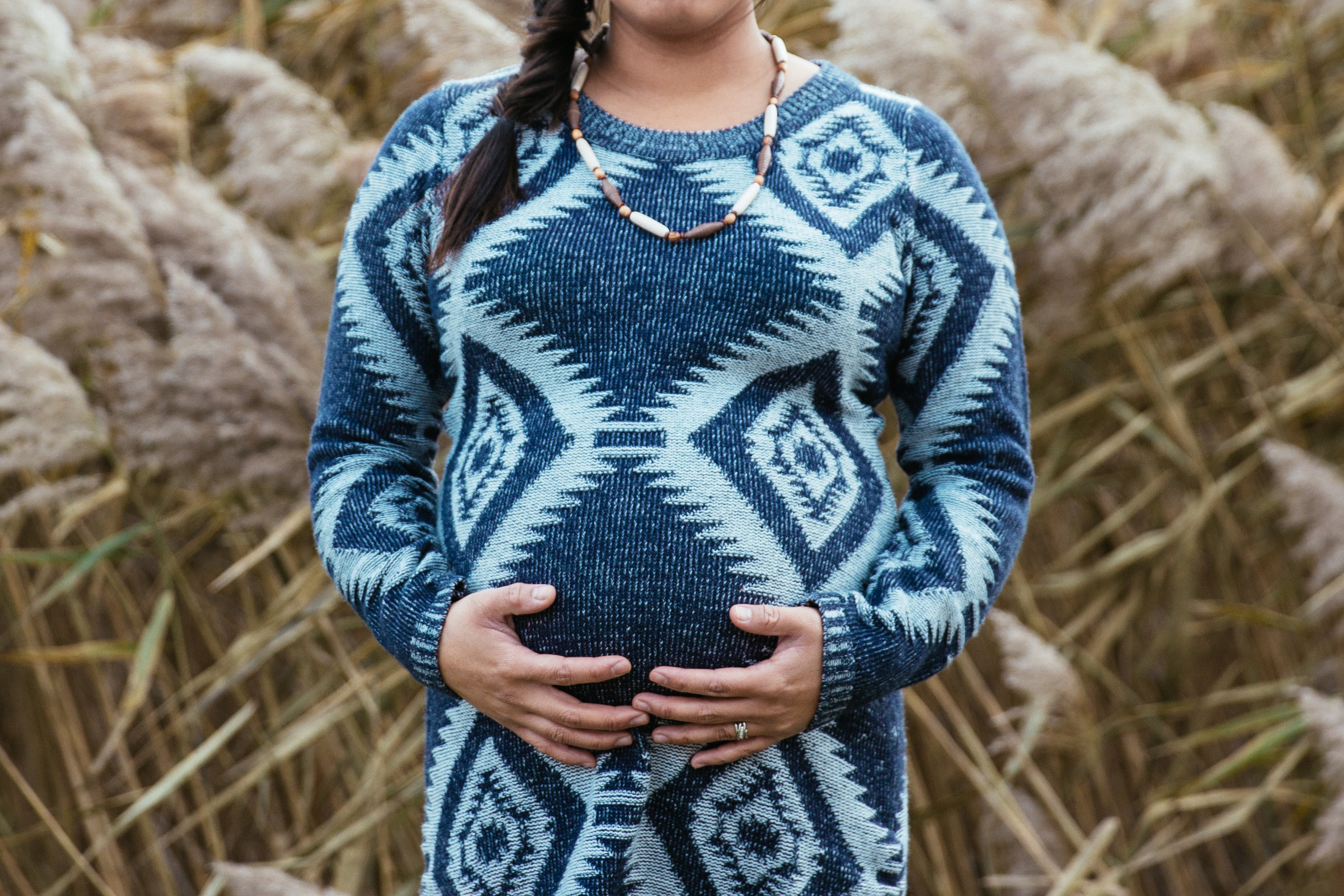 Pregnant mother holding onto her tummy.
