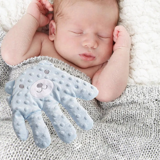 Baby being tapped to sleep by the blue textured electric hand-clapper. 
