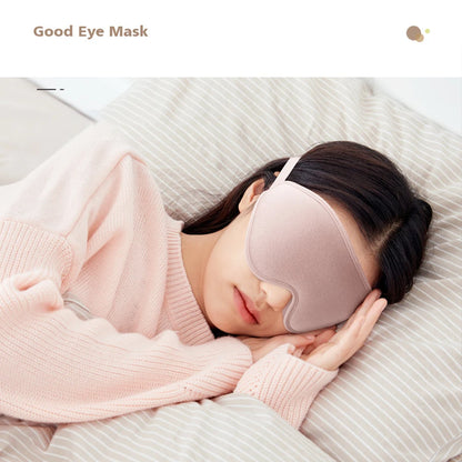 Woman wearing a comfortable pink eye mask while sleeping on a bed.