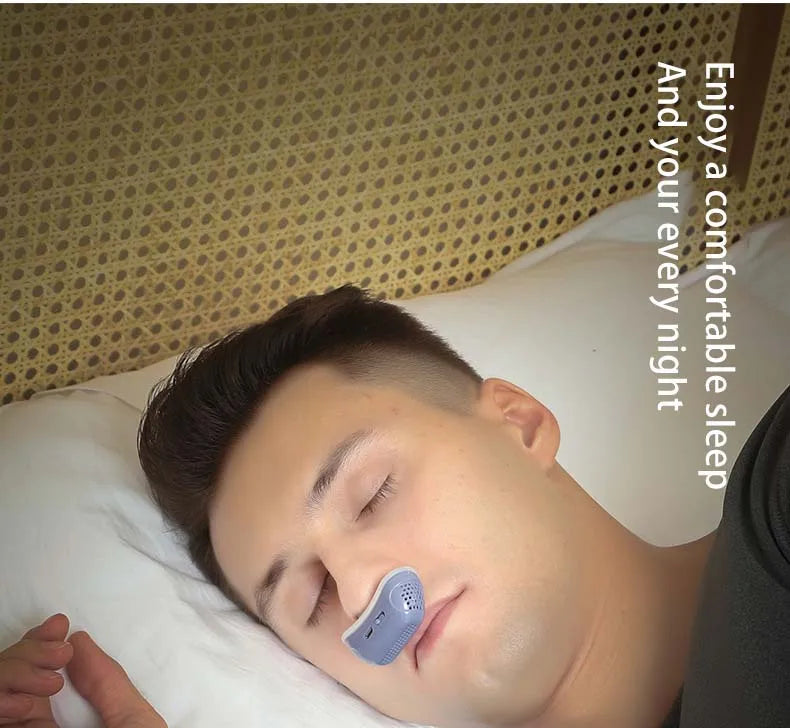 Man sleeping with the anti snoring device on the nose and enjoying  a comfortable sleep.