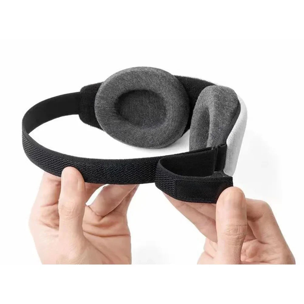 Black and gray headband held by a hand on a white background