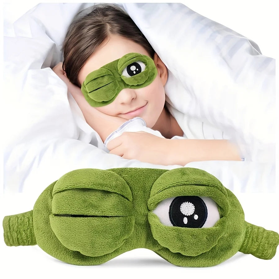 Person wearing a green frog-shaped eye mask with one eye open.