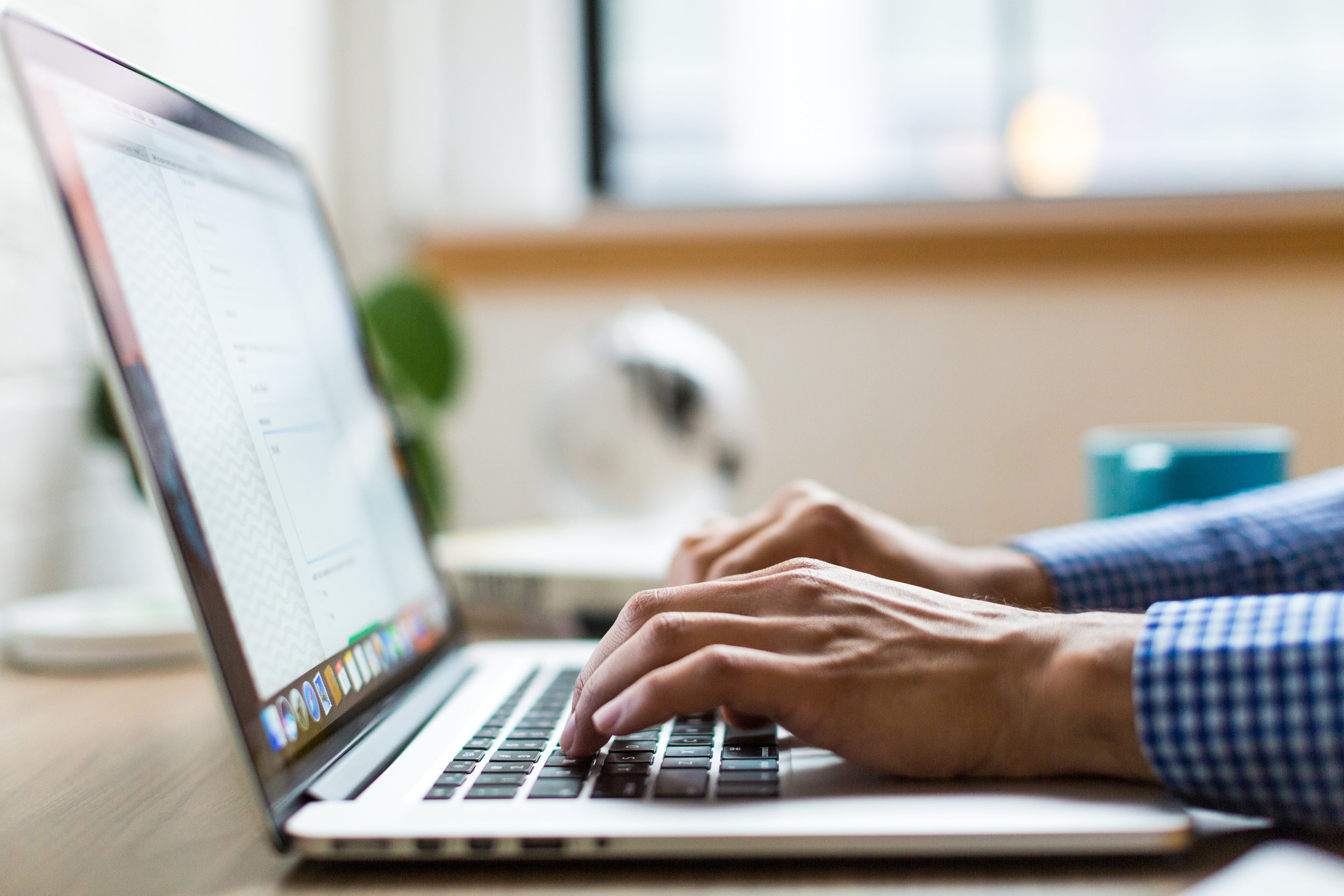 Man typing on a laptop feeling stressed.